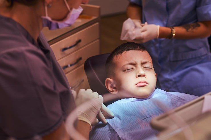 little-scared-boy-is-sitting-denist-chair-waiting-start-treatment-there-are-dentist-her-assistant_613910-21728
